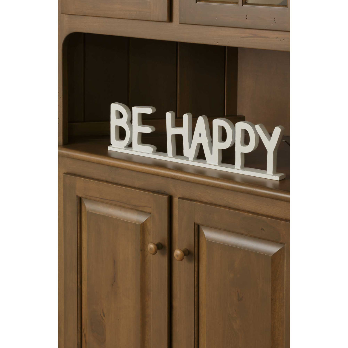 Close-up of the honey stained corner hutch open shelf and raised panel base doors with round wood knobs