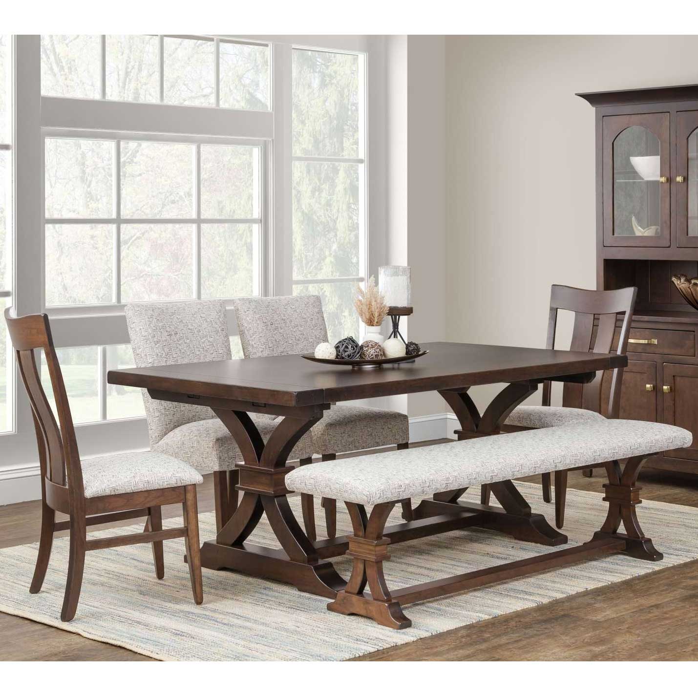Sherwood trestle table with dark plank top and curved trestle base, styled with upholstered chairs, bench and china cabinet
