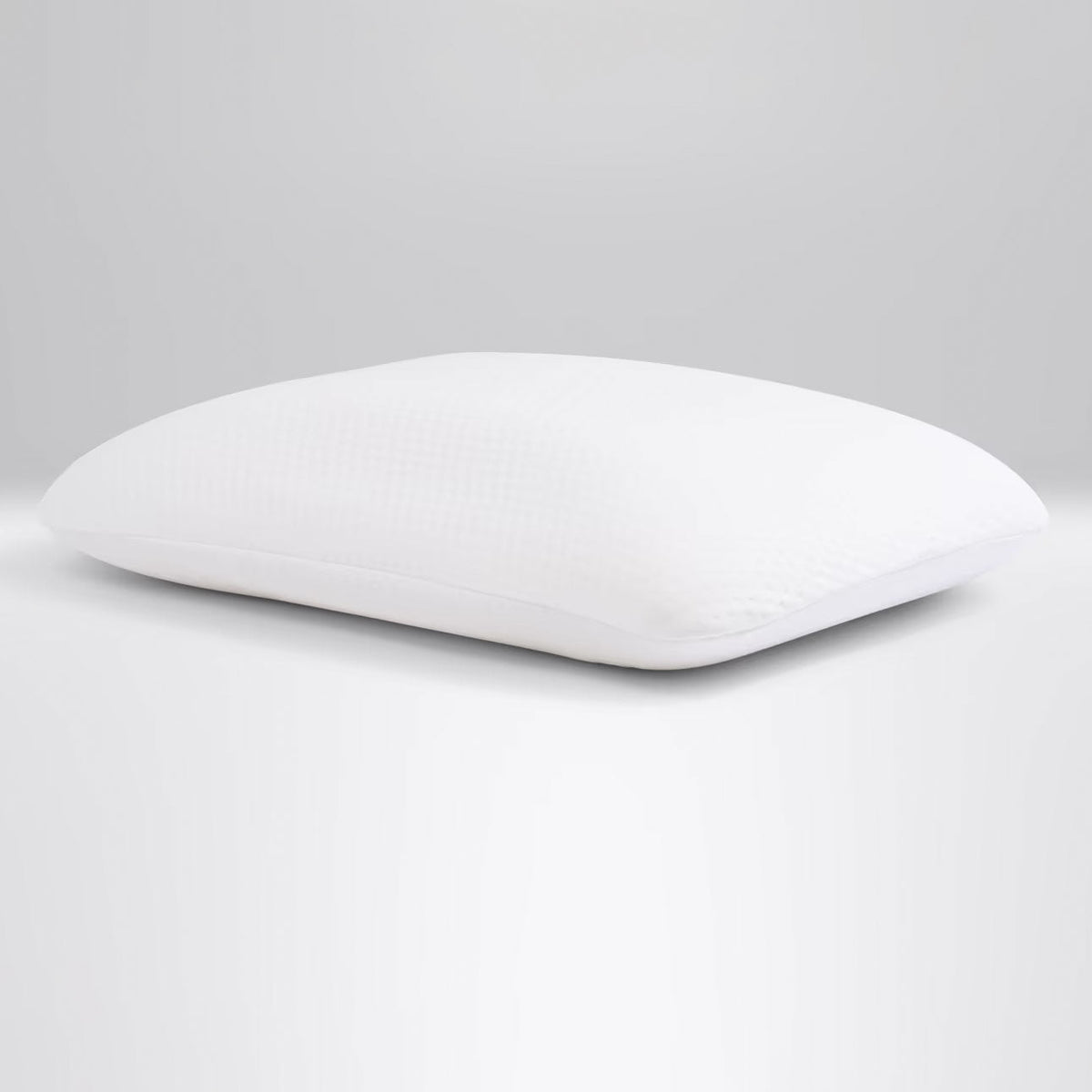 Smooth white memory foam pillow insert with a pebble-knit cover, photographed on a light gray background