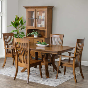 Brown maple expandable pedestal dining table with four curved slat back chairs and a matching corner china cabinet