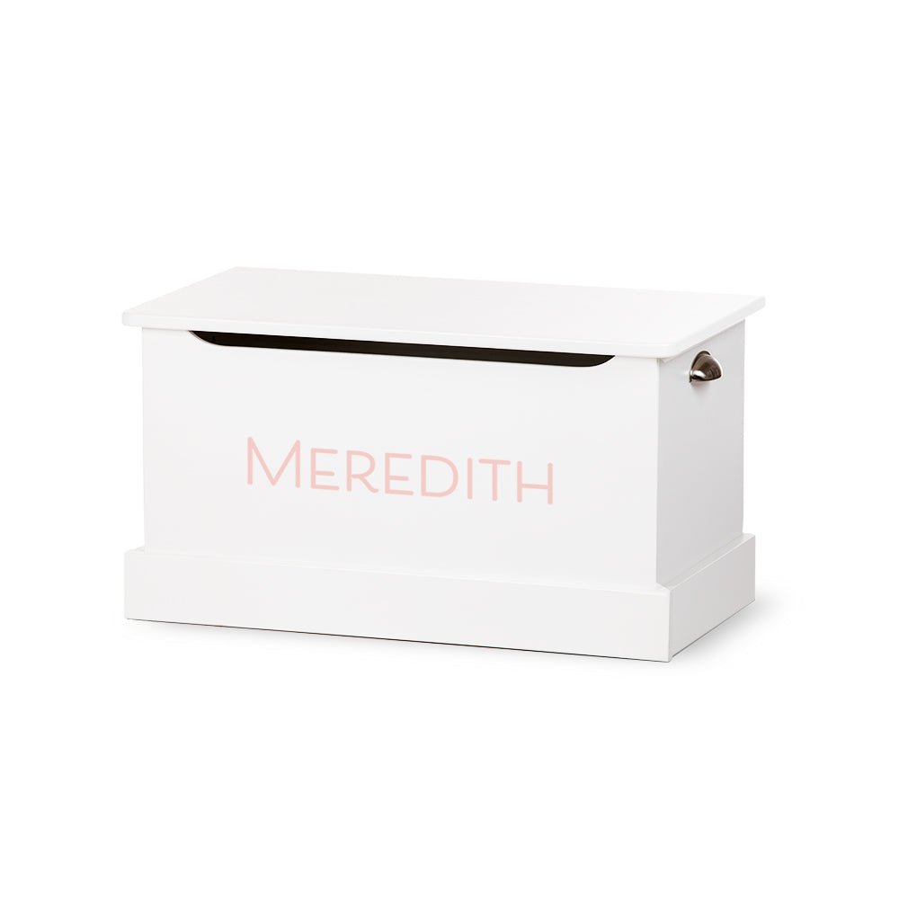 White painted toy chest with the name Meredith in pale pink block letters and a metal cup side handle