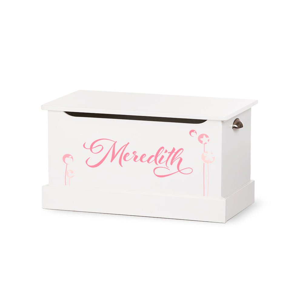 White toy box with a lift lid lettered Meredith in pink script with dandelion accents and side handle