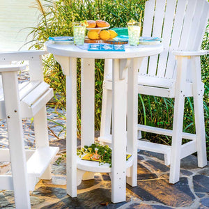 All white poly bar height patio table set with two tall chairs, lemons and drinks on a stone patio by the water
