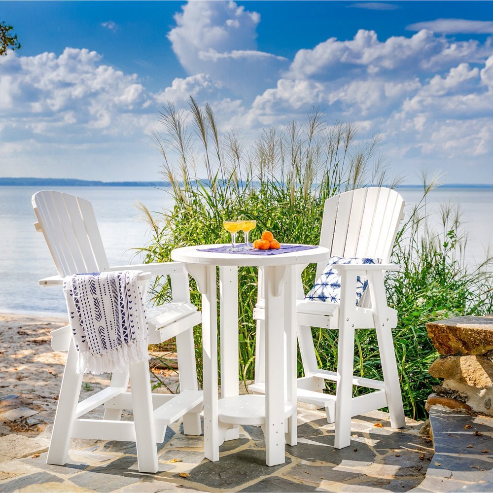 White poly pub table and two tall fanback bar chairs overlooking the bay on a flagstone patio