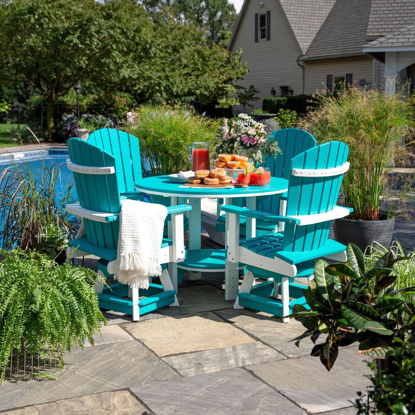 Turquoise and white poly patio dining set with four swivel bistro chairs and brunch beside a pool