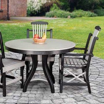 Round poly patio table in weathered wood and black with matching slat back chairs on a paver patio