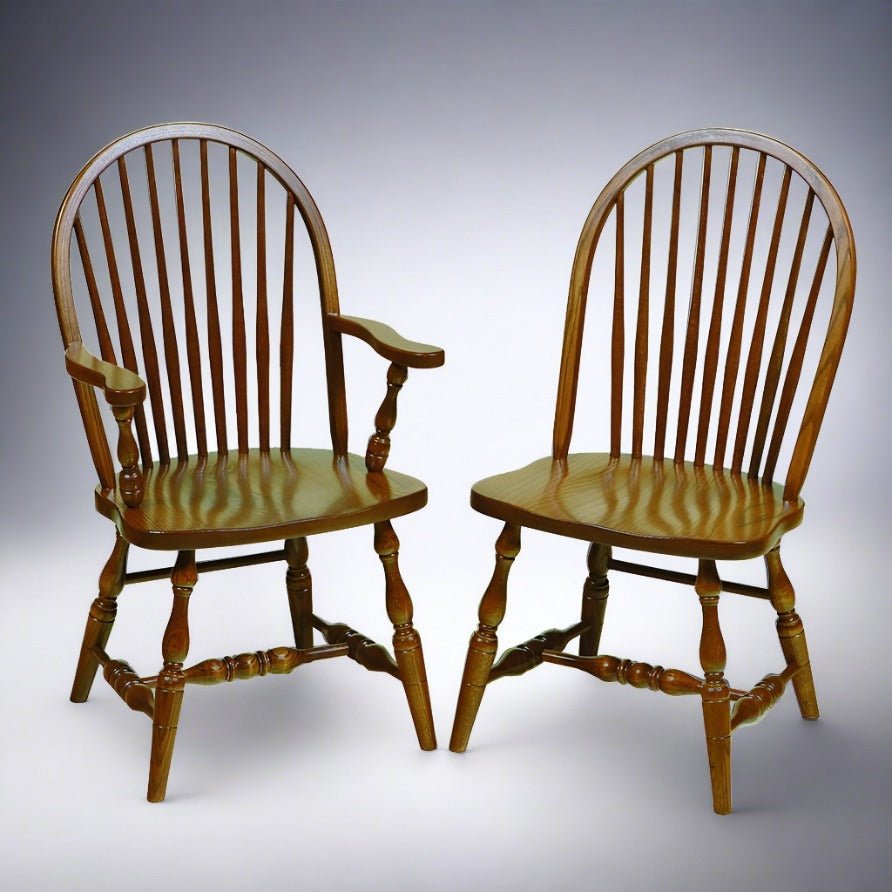 Pair of oak Windsor chairs, one arm chair and one side chair, with bowed spindle backs shown on a gray gradient
