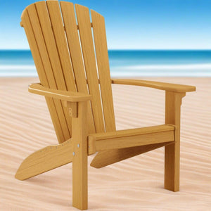 Natural teak colored poly Adirondack chair with a fan slat back and contoured seat on a sandy beach