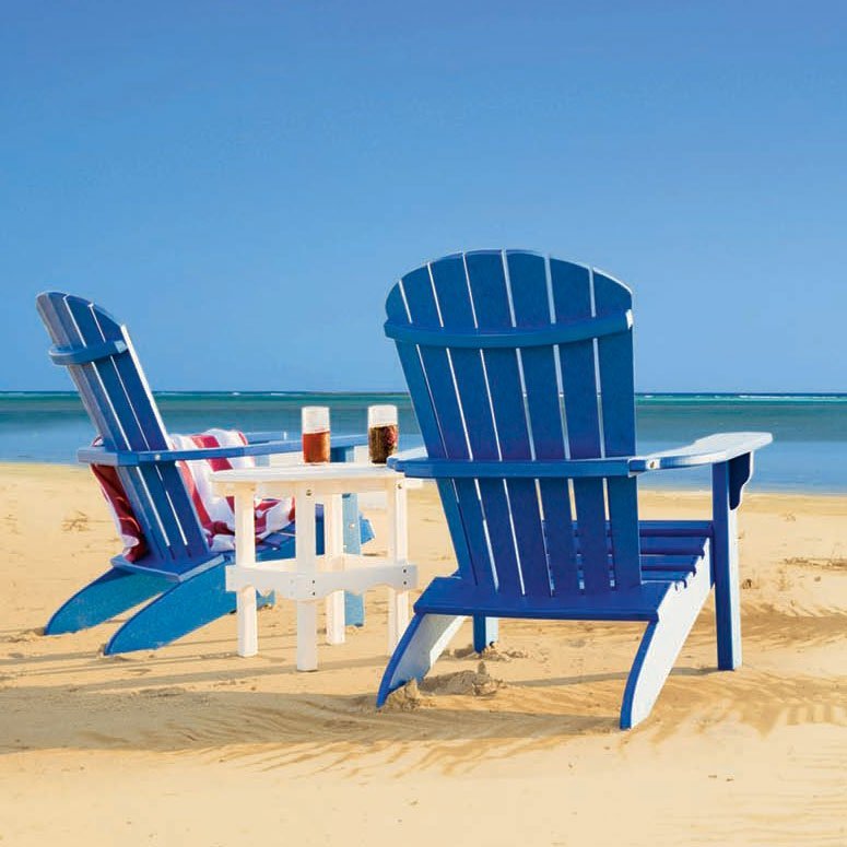 Two gray and white poly Adirondack fanback chairs flanking a white side table beside a swimming pool