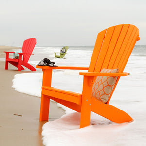 Bright orange poly Adirondack chairs at the ocean edge with red and green chairs down the beach