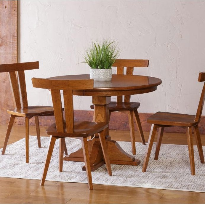 Round Alpine single pedestal dining table in medium cherry with four low-back wood dining chairs on a rug