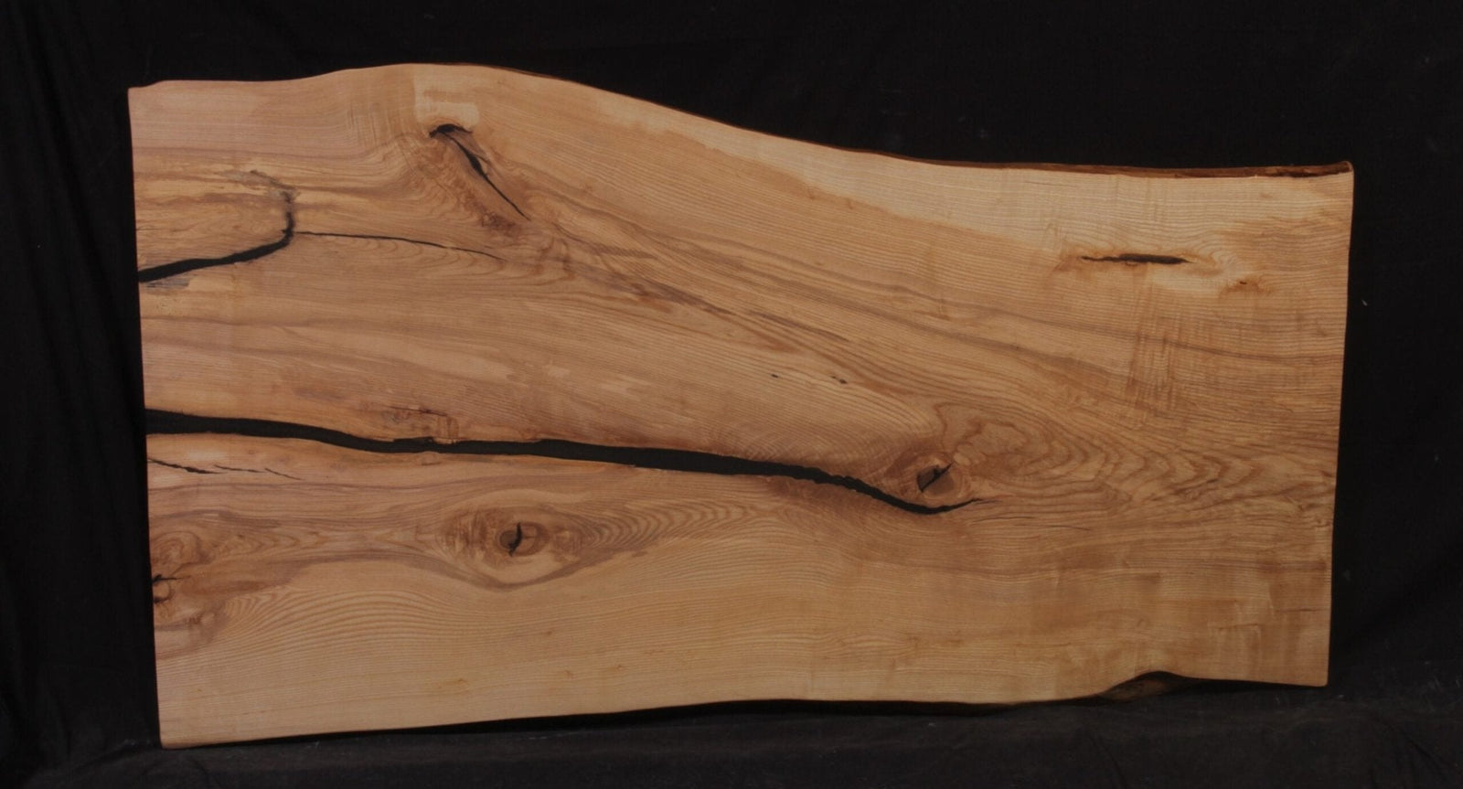 Ash live edge slab with a long black epoxy resin river filling the natural crack down its length