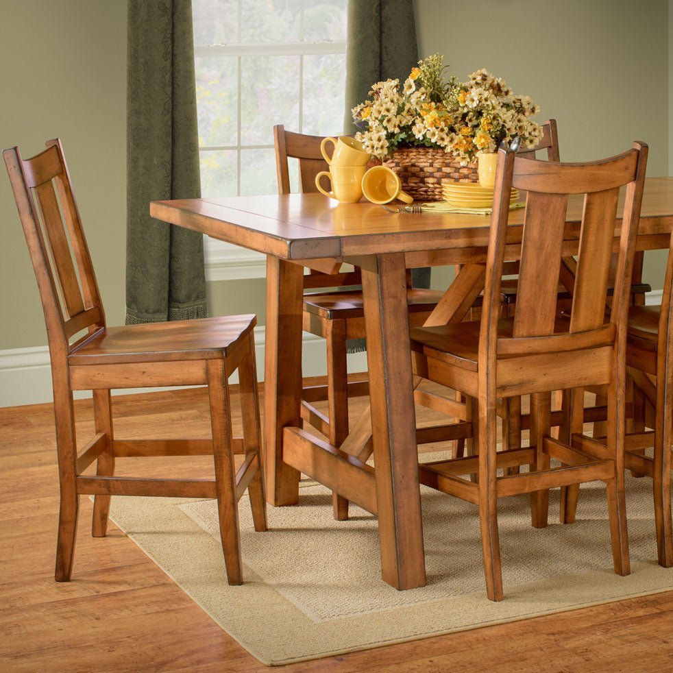 Counter height honey maple trestle table with bar chairs and stools in a dining room with green curtains