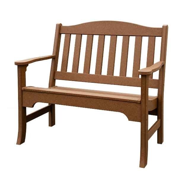 Natural teak poly garden bench with cushions beside a low shelf table at an outdoor stone fireplace