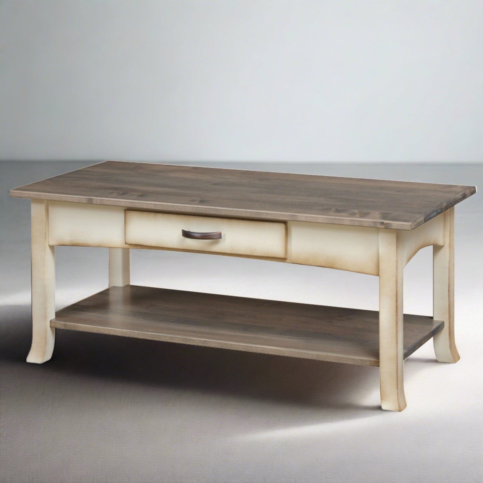 Two-tone coastal coffee table with a weathered gray top, cream painted base, drawer and lower shelf in a living room