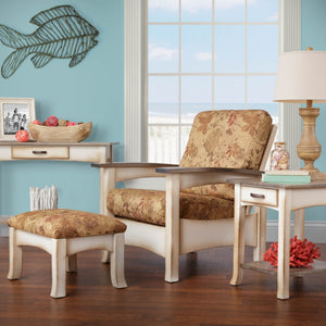 Coastal Morris chair with floral cushions and cream painted frame paired with an ottoman in a beach themed room