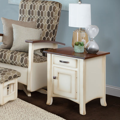 Cream painted enclosed end table with cherry top, one drawer and a cabinet door, styled with a lamp beside a glider