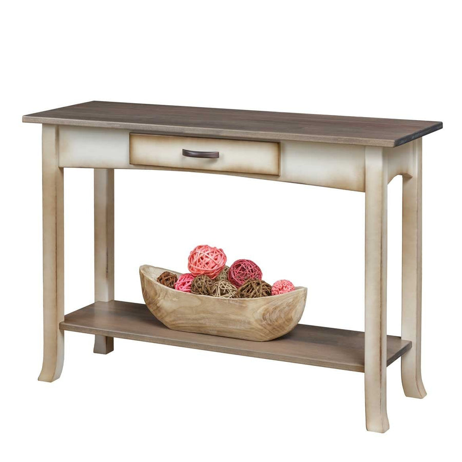 Two-tone console table styled with a wooden bowl of decorative balls on its lower shelf, on a white background