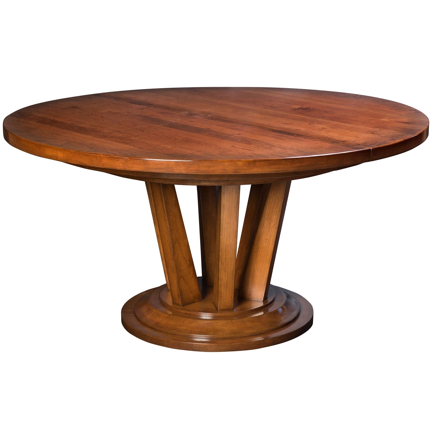 Round cherry pedestal dining table set with four curved back chairs and cream seats in a rustic dining room