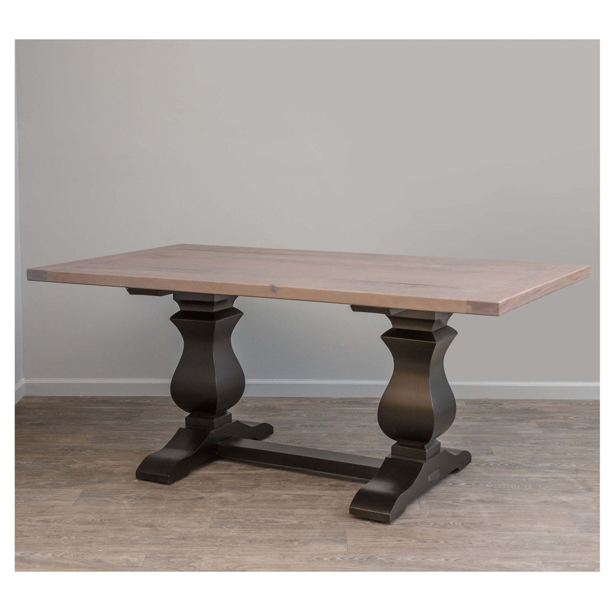 Calistoga trestle dining table with a driftwood gray plank top on black turned pedestal bases and shaped feet