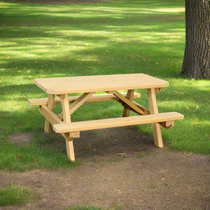 Kid size wooden picnic table with attached benches and natural pine finish, set on grass under a tree