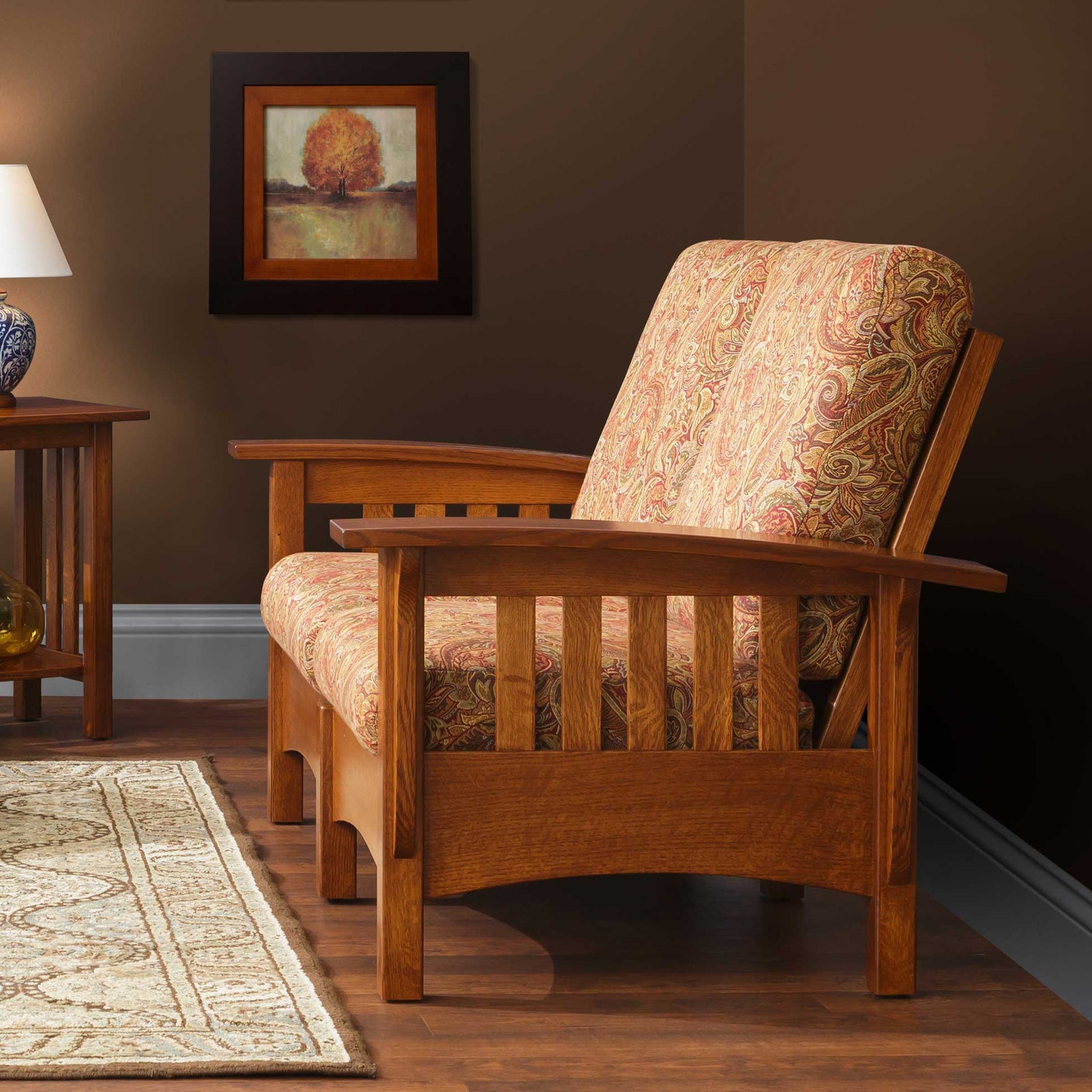 Mission oak Morris loveseat with light gray cushions in a bright sunroom with tall windows behind