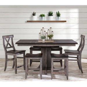 Dark gray gathering table with butcher block style top, X back chairs and saddle counter stools by shiplap wall