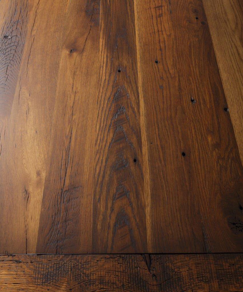 Close-up of the reclaimed oak top showing wide planks, nail holes, checks and a warm hand-rubbed finish
