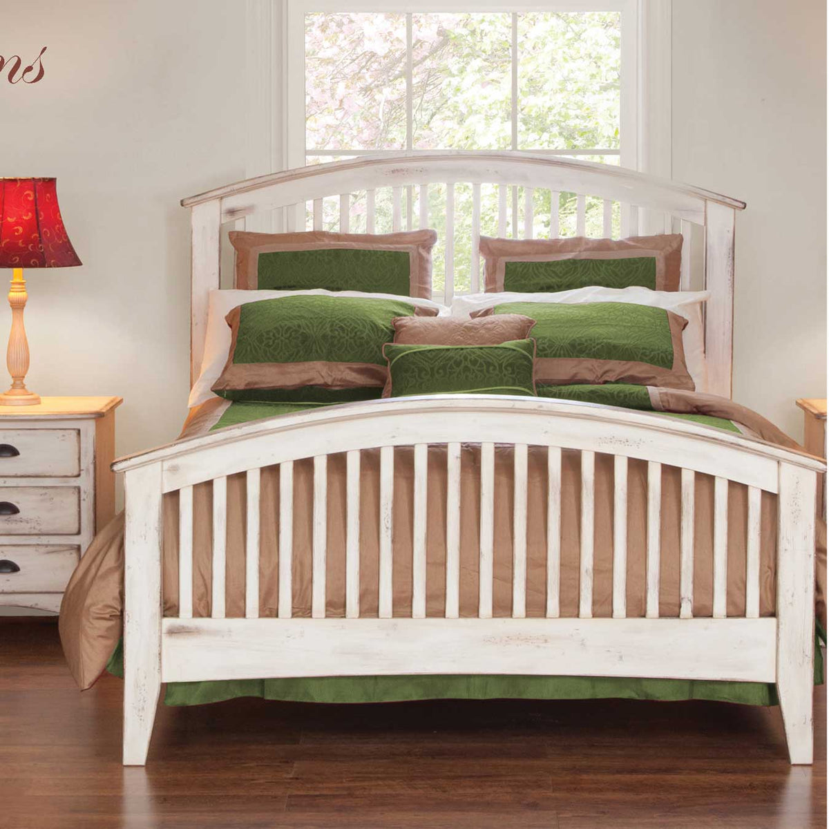 Antique white spindle bed with arched slat footboard beside a distressed nightstand and green bedding