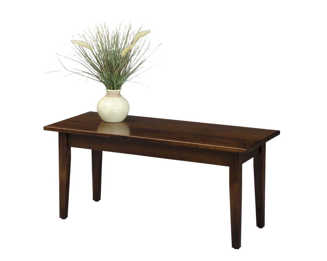 A dark brown wooden coffee table in a styled living room setting, featuring a beige sofa, a patterned area rug, and decorative items on the tabletop.