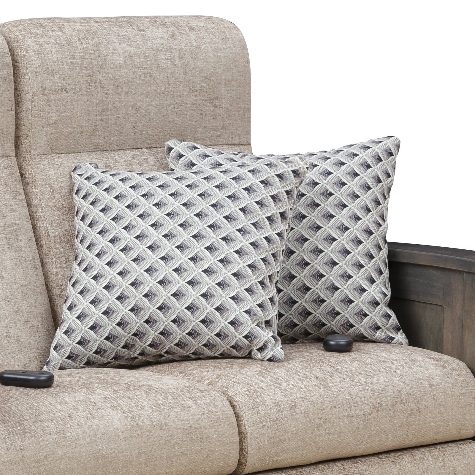Pair of throw pillows in a gray and cream geometric lattice weave resting on a tan reclining sofa
