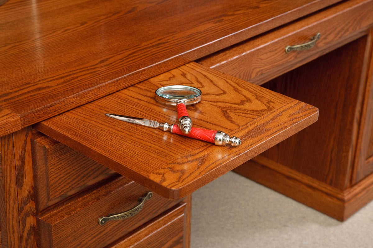 Writing slide pulled from beneath the oak desk top, holding a magnifying glass and red letter opener