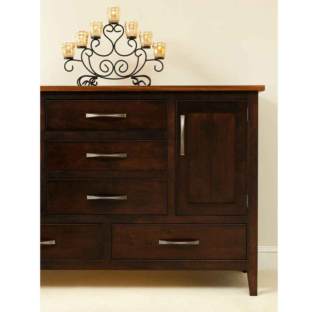 Front view of the two-tone dining sideboard with drawers, a panel door and an iron candelabra on the oak top