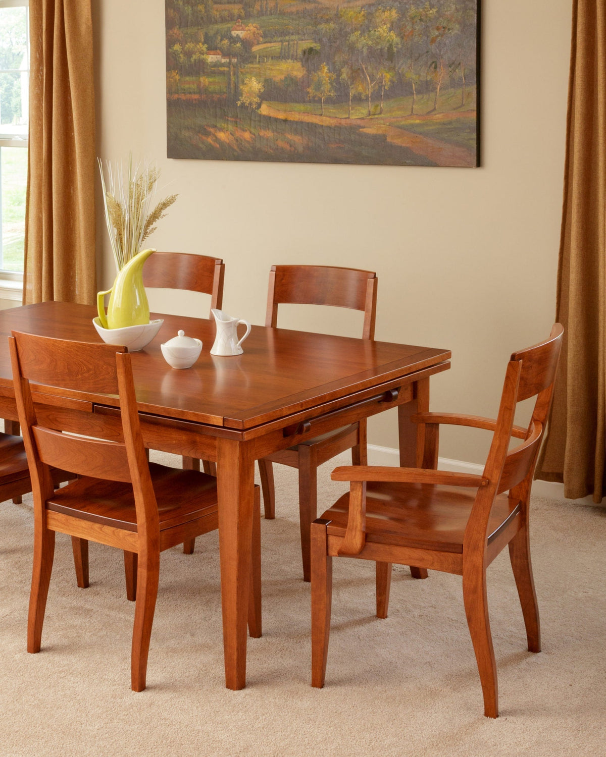Cherry dining table with a draw leaf and modern curved back chairs including an arm chair on carpet