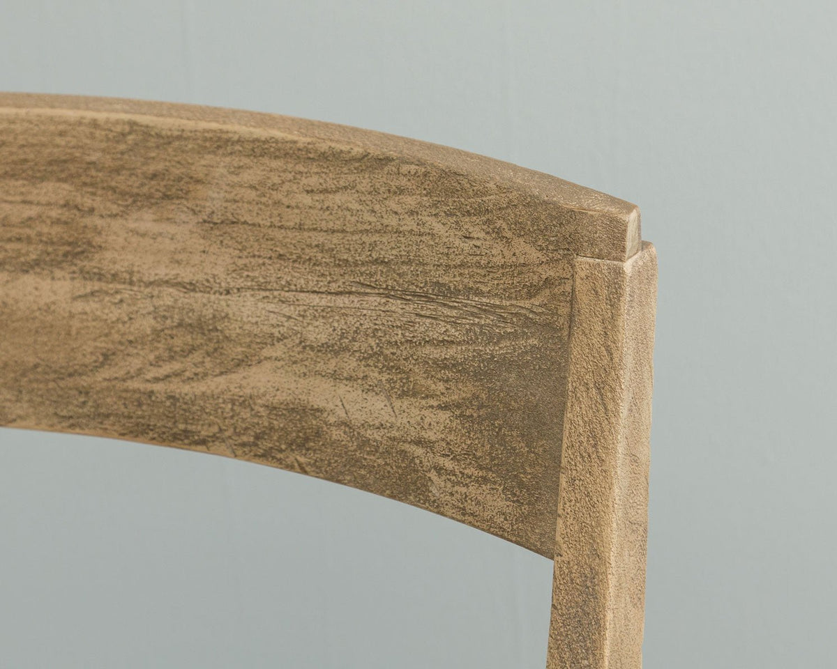 Close up of a weathered chair crest rail showing the curved slat, saw textured grain and corner joinery