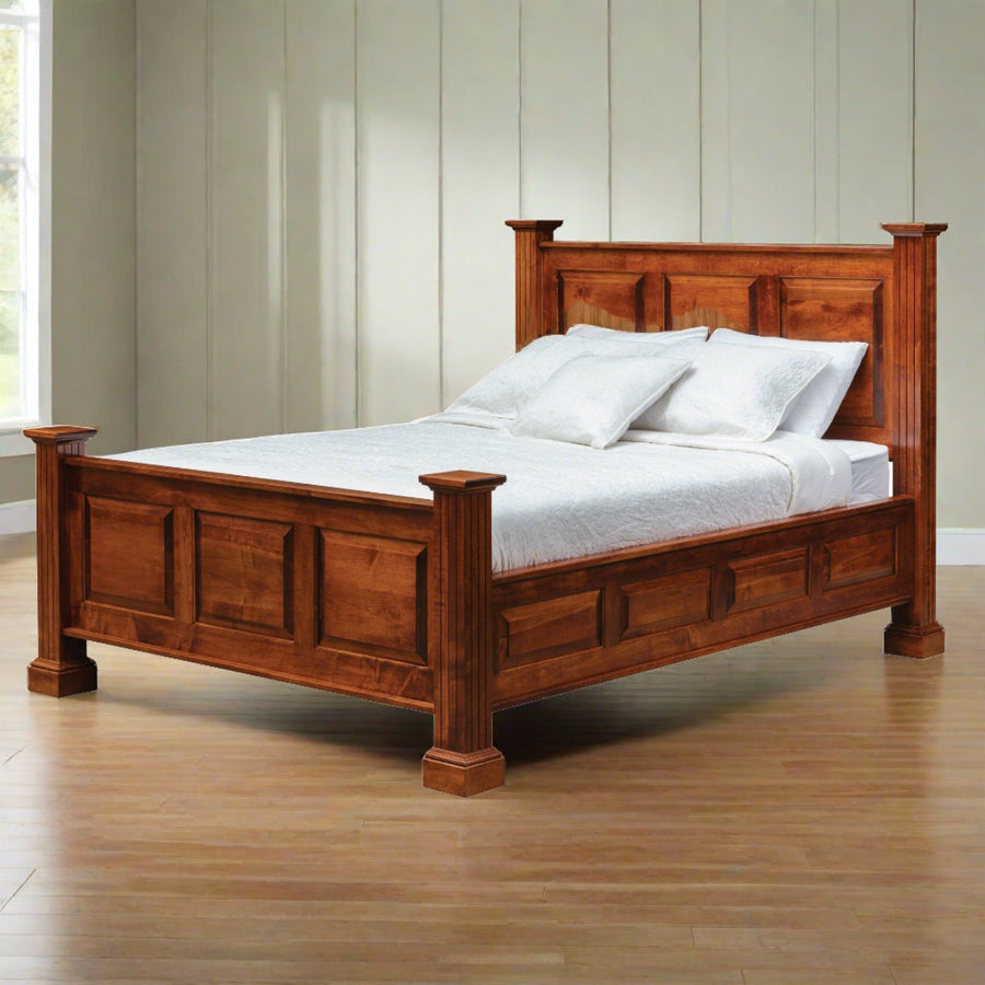 Raised panel bed with tall square posts and paneled headboard and footboard in a warm cherry finish