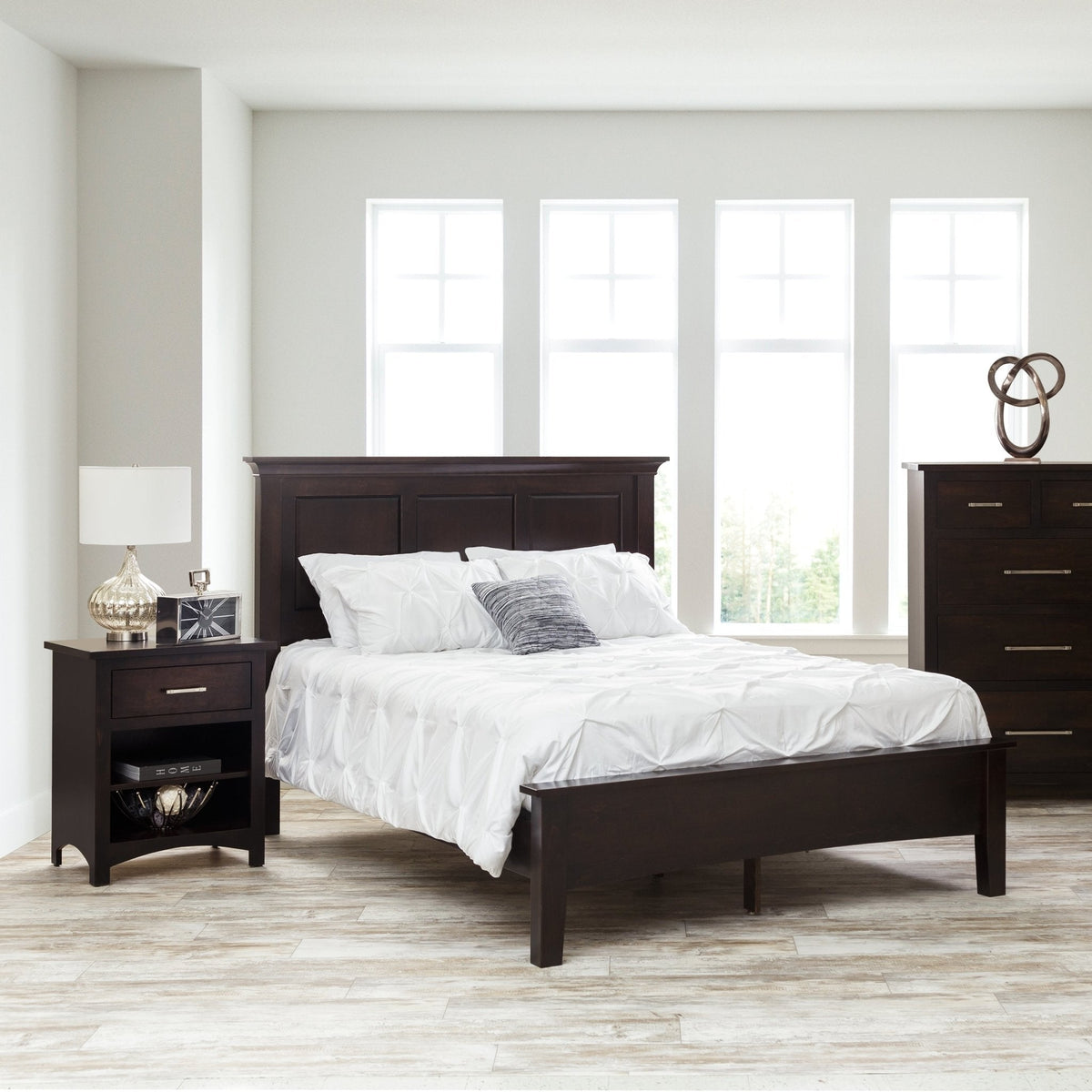Espresso panel bed with a raised three-panel headboard and low footboard, white bedding and open nightstand