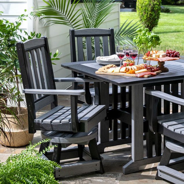 Gray poly swivel dining arm chairs with slat backs at a rectangular patio table set with a charcuterie board