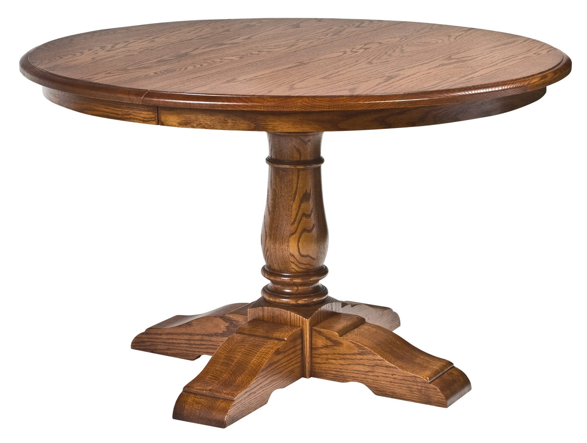 Oak round expandable dining table shown straight on, with a heavy turned pedestal and carved cross foot
