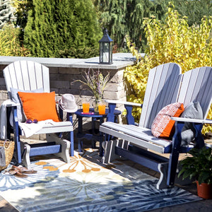Gray and navy poly fanback glider chair, glider loveseat and round side table on a floral outdoor rug