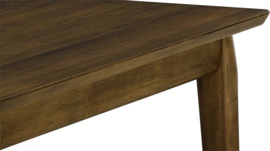 Close up of a mid century table corner showing the chamfered top edge and tapered leg in walnut