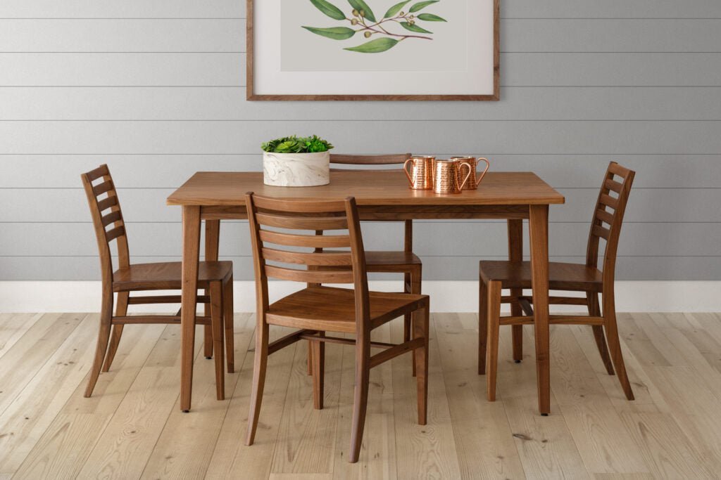 Walnut leg table with four ladder back chairs and copper mugs in a gray shiplap dining nook