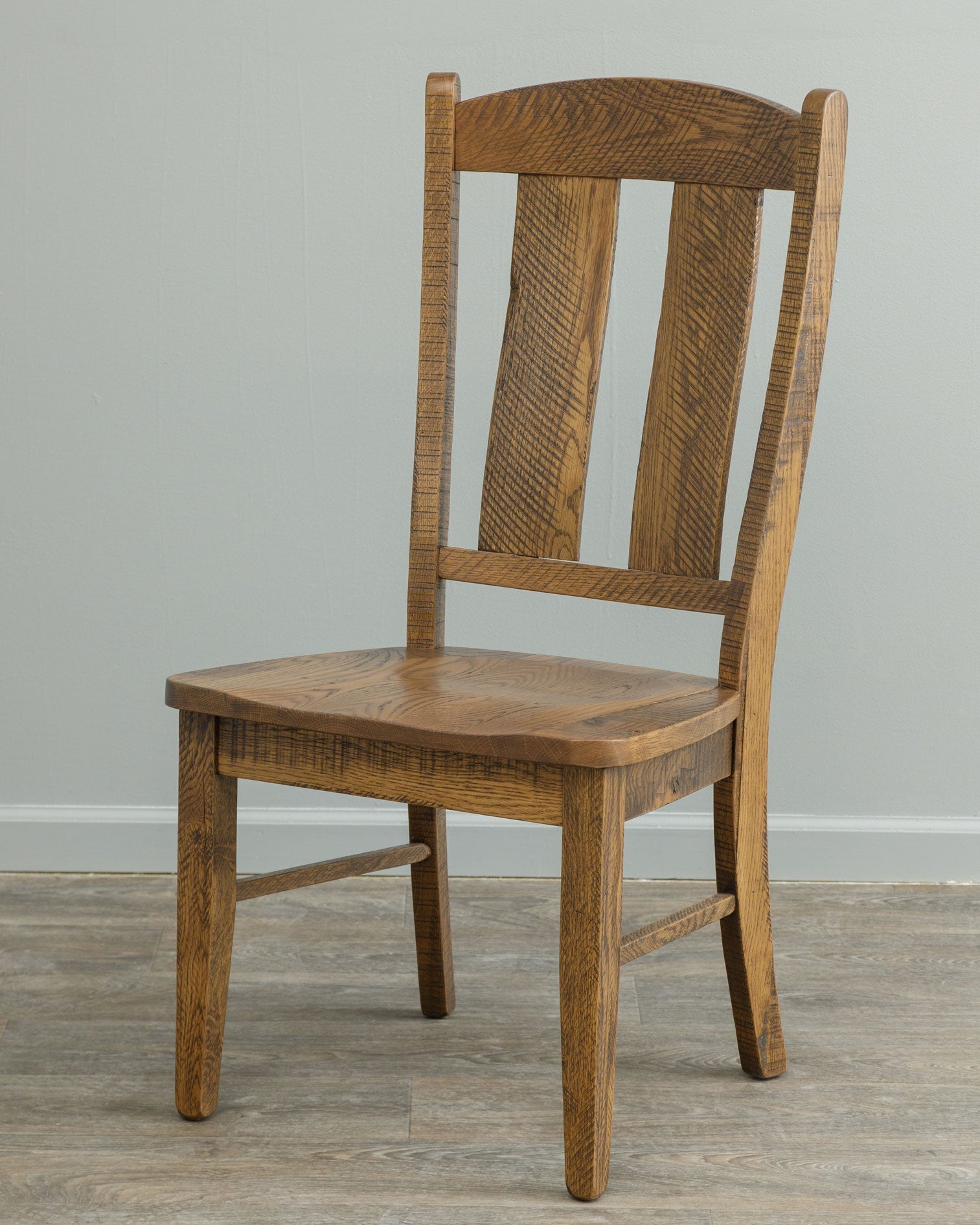 Light stained dining set with a turned leg table, arm chair and side chairs with shaped back slats