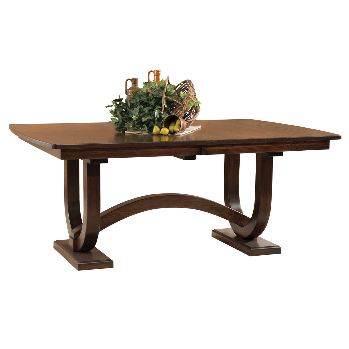 Extendable trestle dining table in warm brown cherry with arched pedestal base, styled with a basket of greenery and pottery