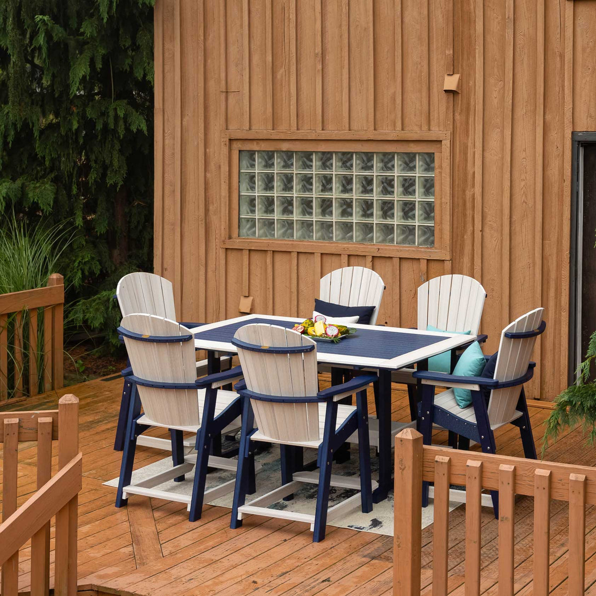 Navy and white poly counter height patio table with six fan back chairs on a deck by a wood sided cabin