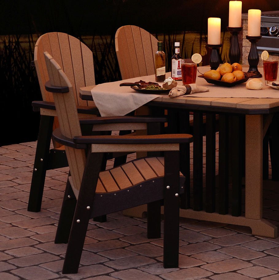 Cedar and black poly Adirondack dining chairs at a patio table set with candles on a paver terrace