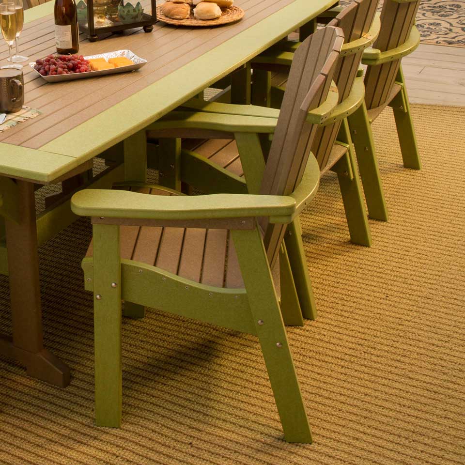 Lime green and cedar poly Adirondack dining chairs pulled up to a matching table on a woven rug