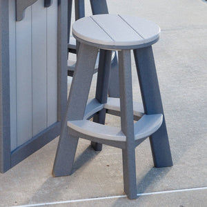 Gray two-tone poly backless round bar stool with light seat and footrest beside an outdoor bar