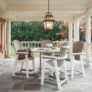 Gray and white poly counter table with four fan back bar chairs under a covered stone porch