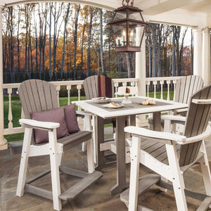Driftwood gray and white poly bar table with four tall Adirondack chairs on a stone porch in autumn